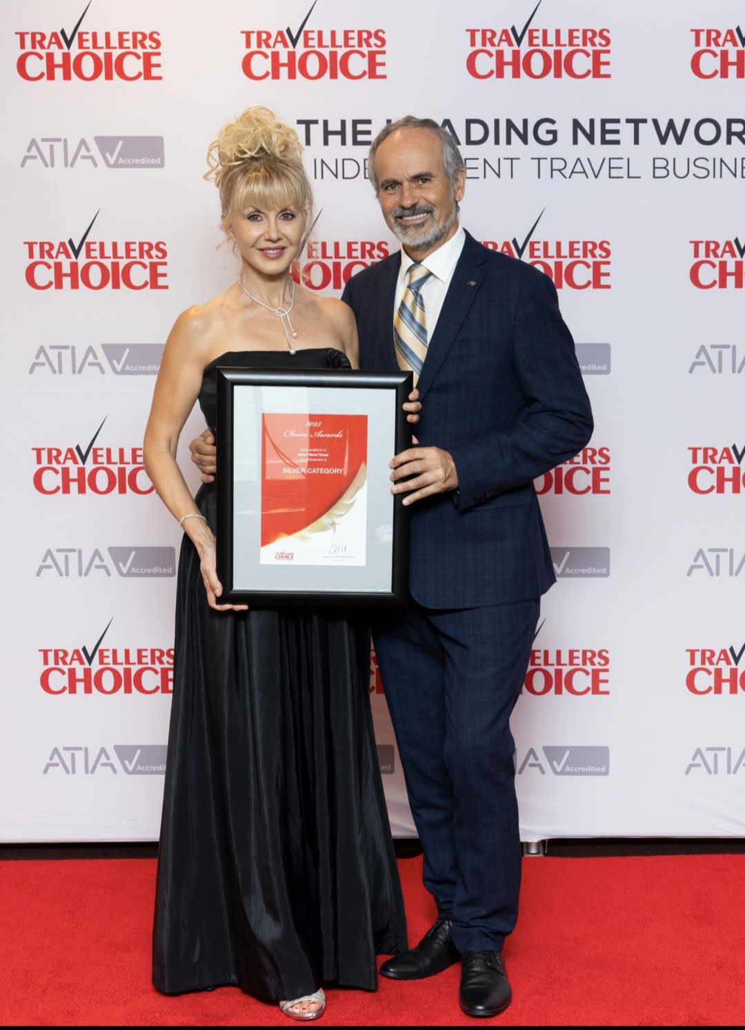 Chip and Michelle, founders of Select World Travel, holding their Travellers Choice award at the awards gala