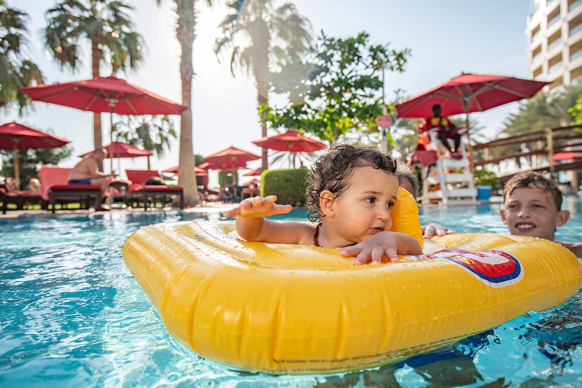 Family beach resort escape — kids in a lagoon pool